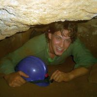 Crawling through a narrow tunnel in Westminster Cave